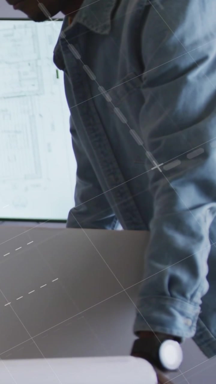 Vertical video: Man unrolling blueprint, blue overlays sliding over sheet inspecting design plans