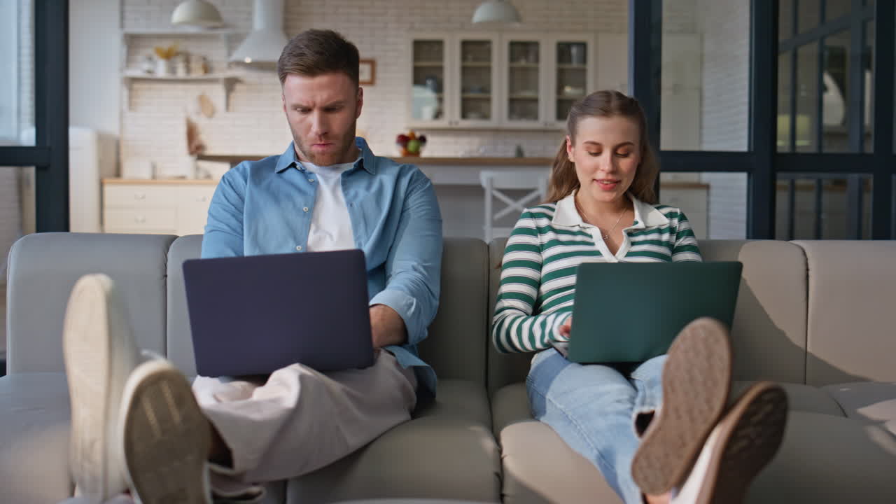 Freelancers couple working laptops at domestic interior. Happy wife husband