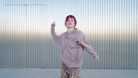 young urban dancer performing various moves in front of metal wall