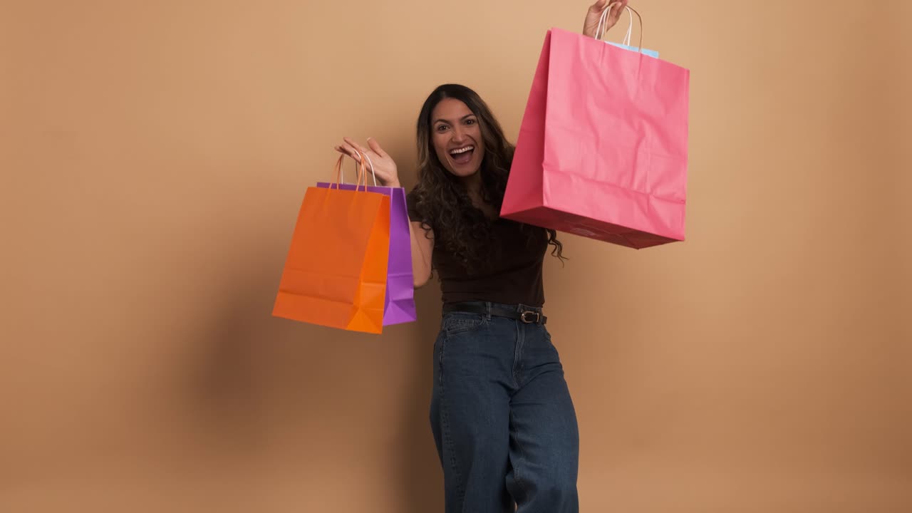 Happy woman showing and holding many shopping bags