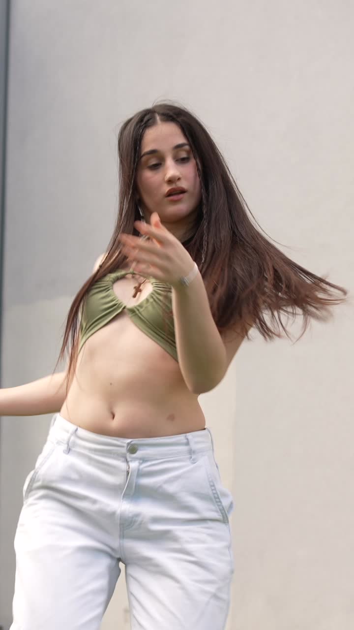 Dancing woman in green top and white pants