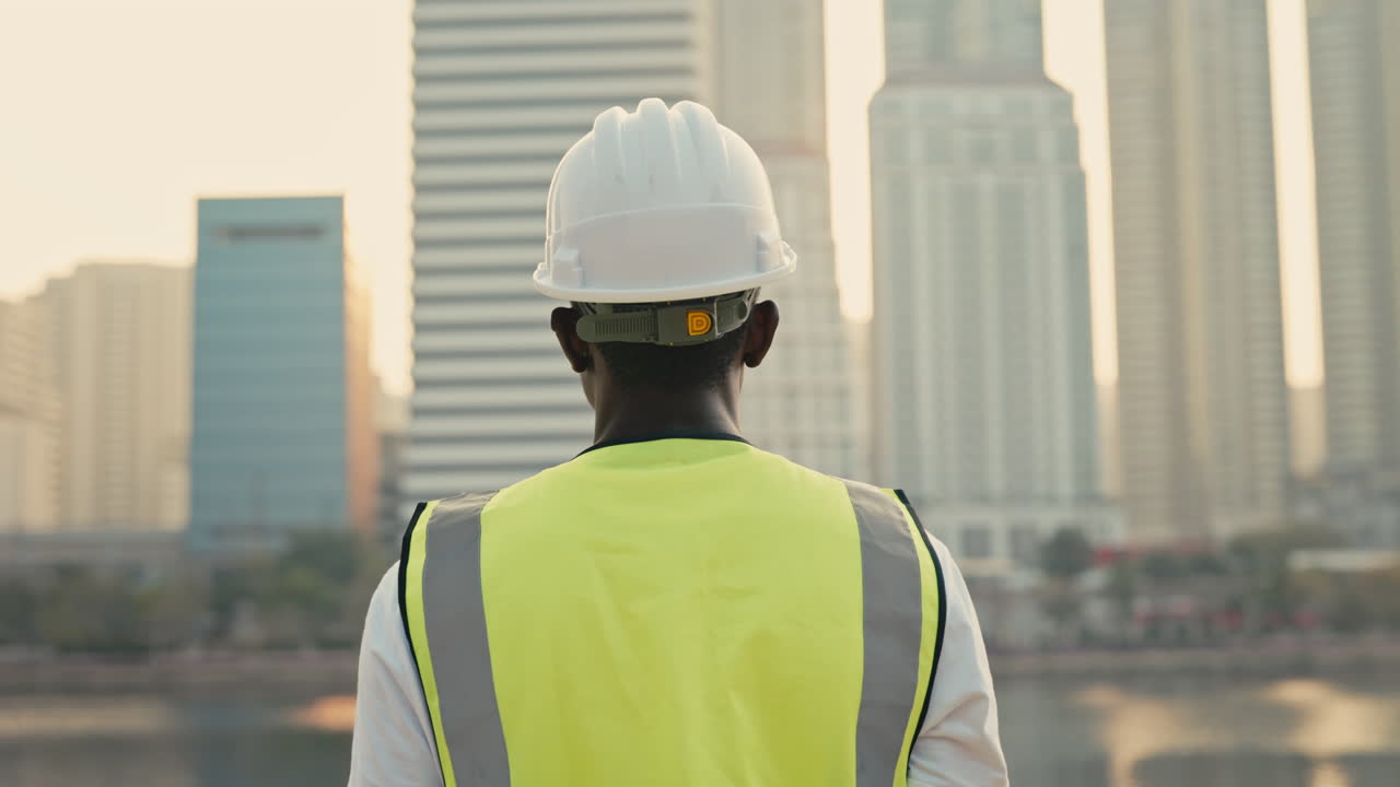 Construction worker looking at cityscape