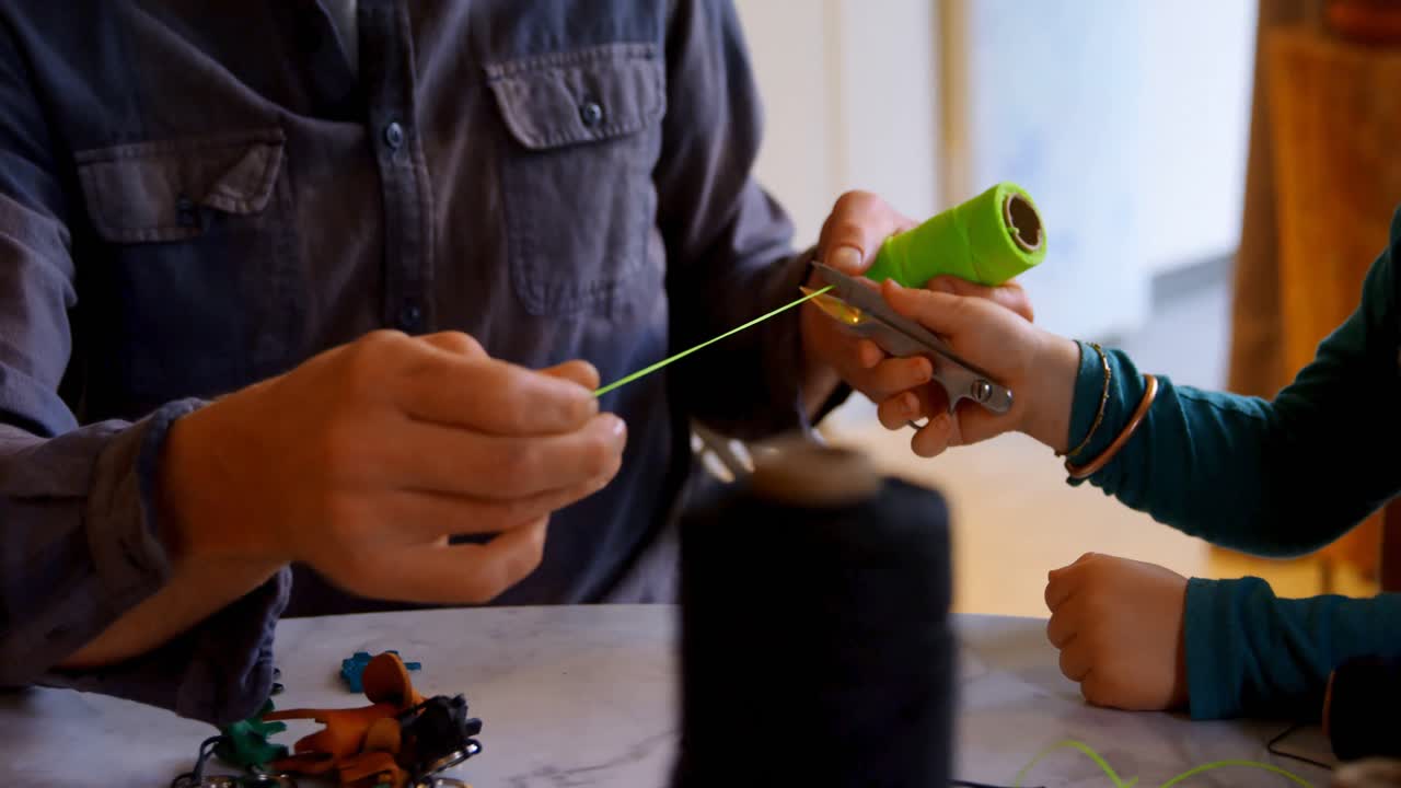 padre e hijo sosteniendo un rollo de hilo en casa 4k
