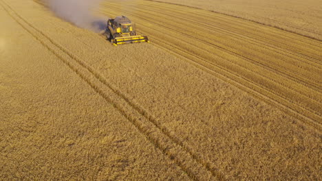 front angled view of combine harvester spinning as it mows through open fields