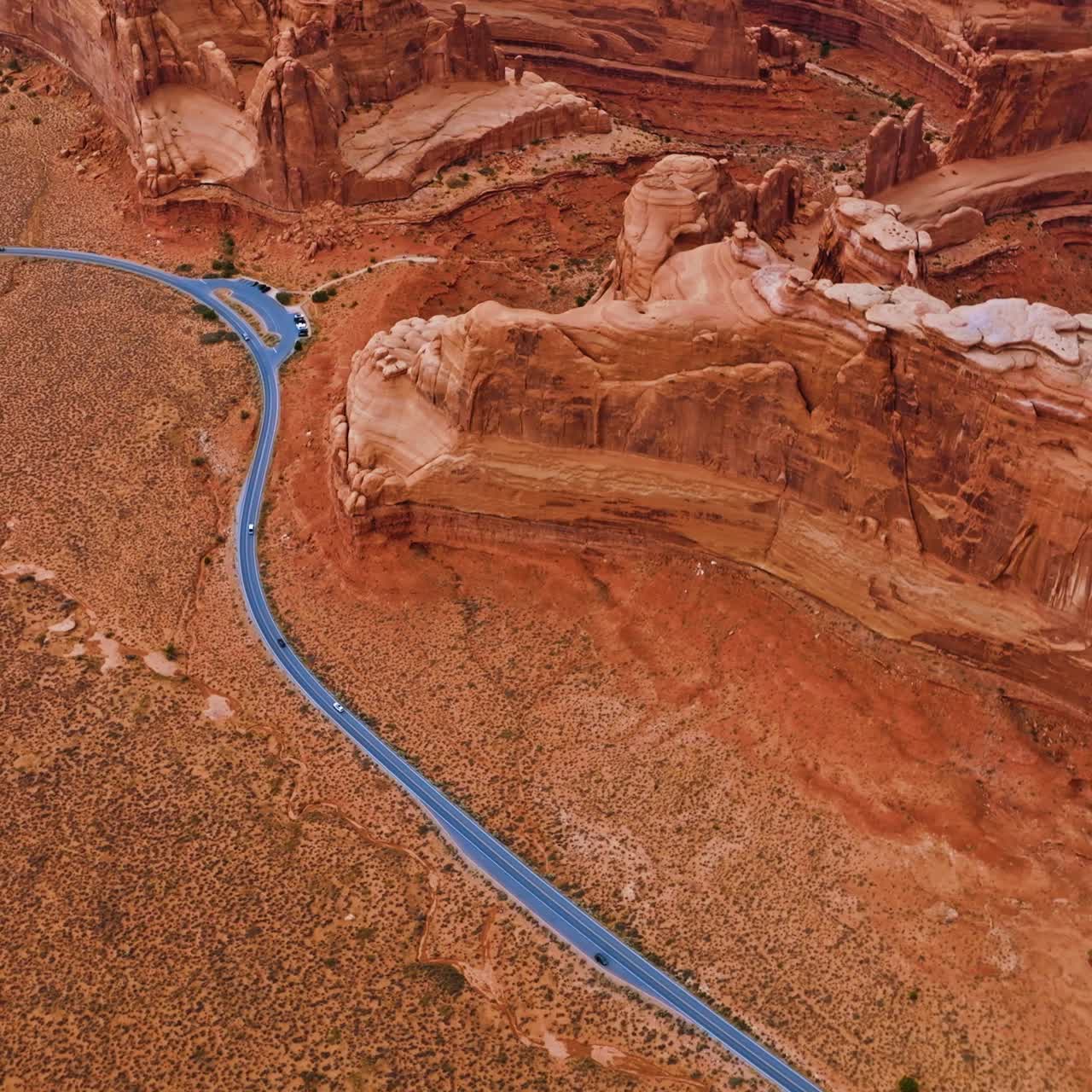 Flying high above the road going round the stunning rocks in Bryce canyon. Quick cars riding along the plain at the foot of mountain rocks