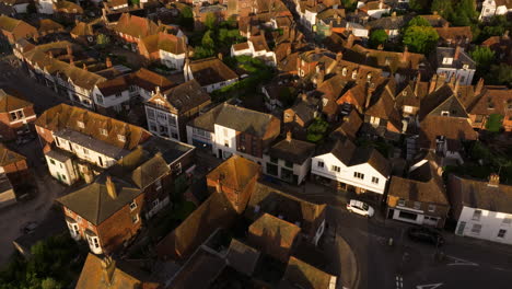 flying over the streets and houses in rye town during golden hour at dusk in england, uk. - aerial tilt up shot
