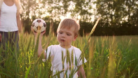 boy in white shirt walking in a field directly into the camera and smiling in a field of spikes