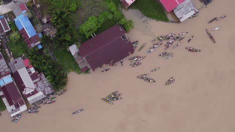 Arriba-Hacia-Abajo-Del-Famoso-Mercado-Flotante-En-Banjarmasin-En-El-Río-Marrón,-Antena