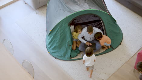 funny daddy and three kids playing camping