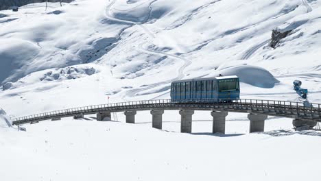 藍色電缆車向下行駛, 周圍是雪地冬天風景和聖地的山脈