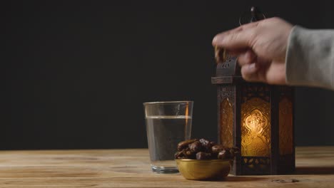 toma estacionaria de la mano tomando una cita en una mesa para ramadán.