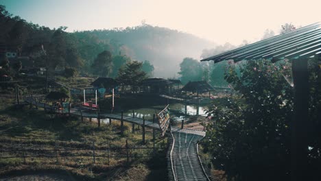 vista superior de una pequeña aldea reunida alrededor de algunos campos de arroz en tailandia