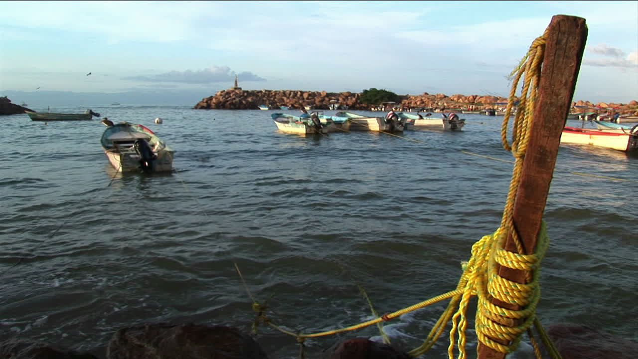 부두 기둥에 묶인 모터 보트가 파도에 흔들립니다.