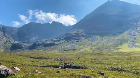 Panning-shot-of-some-mountains-near-the-Fairy-Pools-on-the-Isle-of-Skye-in-Scotland-on-a-bright-summer-day