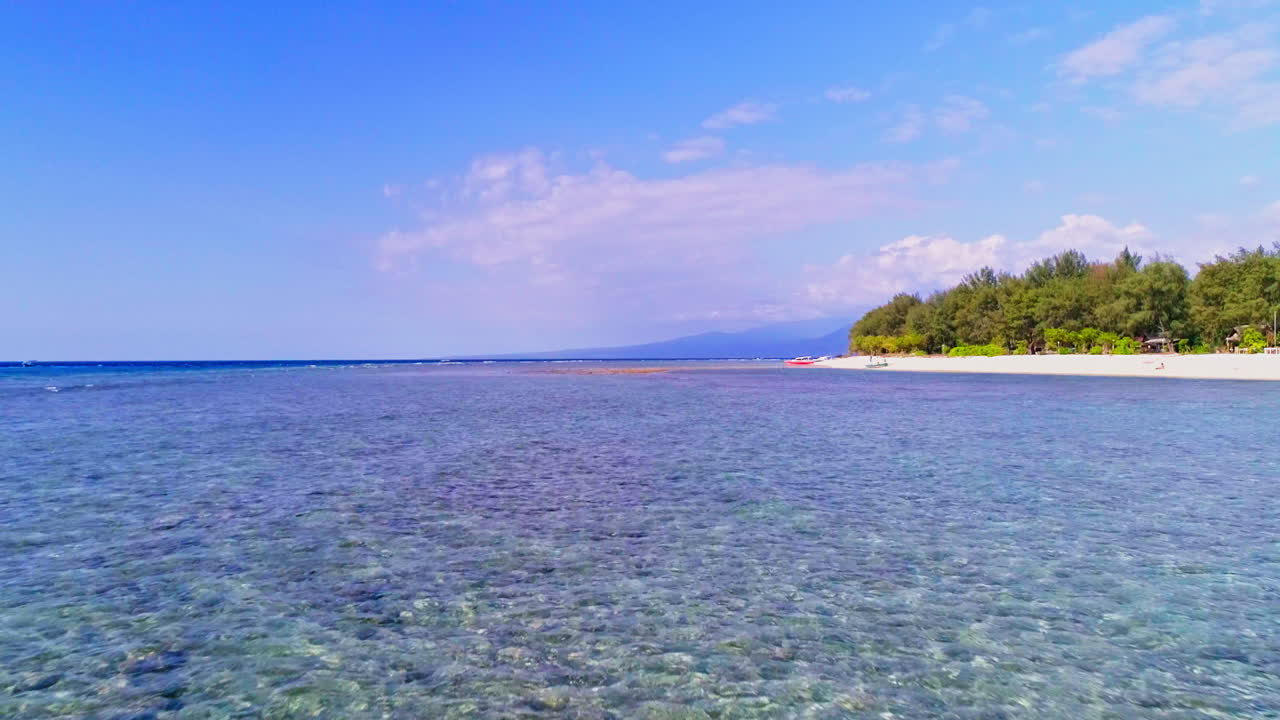 Stunning aerial footage of the Gili Islands, Indonesia. Crystal-clear waters, white sand beaches, coral reefs, and boats in paradise. Ideal for travel, nature, and tropical themes
