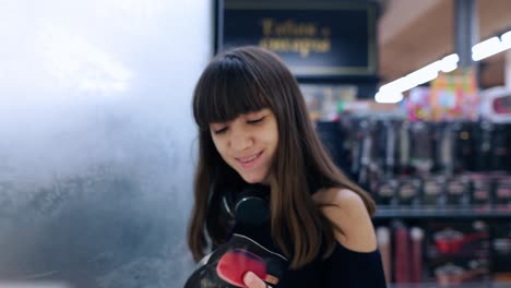 adolescente morena en el supermercado, abre la puerta del congelador y toma un helado del estante