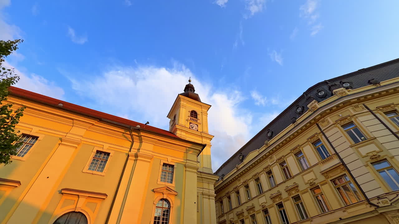 Walls of the historical buildings lit by the setting sun. Walking by the streets of Sibiu, Romania. Low angle view