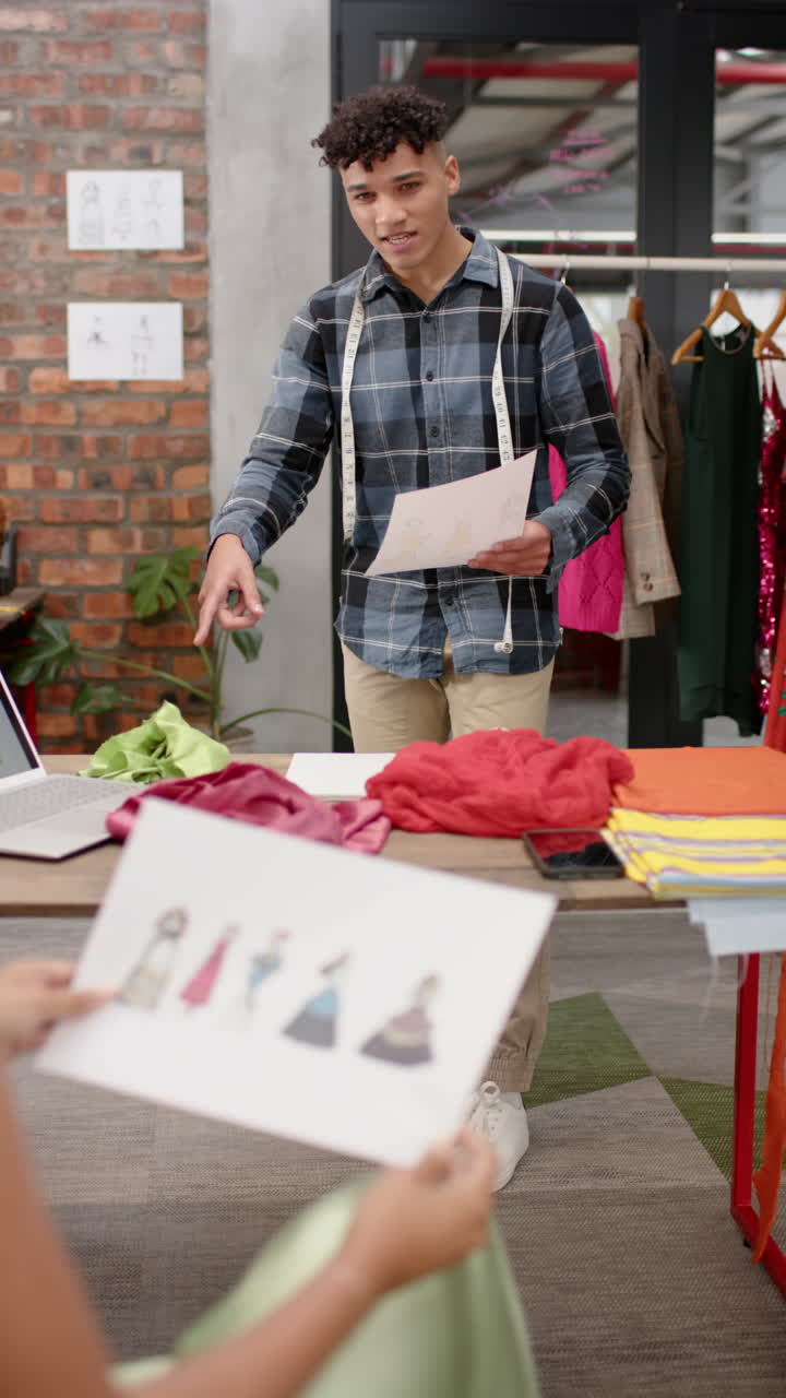 Vertical video of diverse business people discussing work in creative office in slow motion