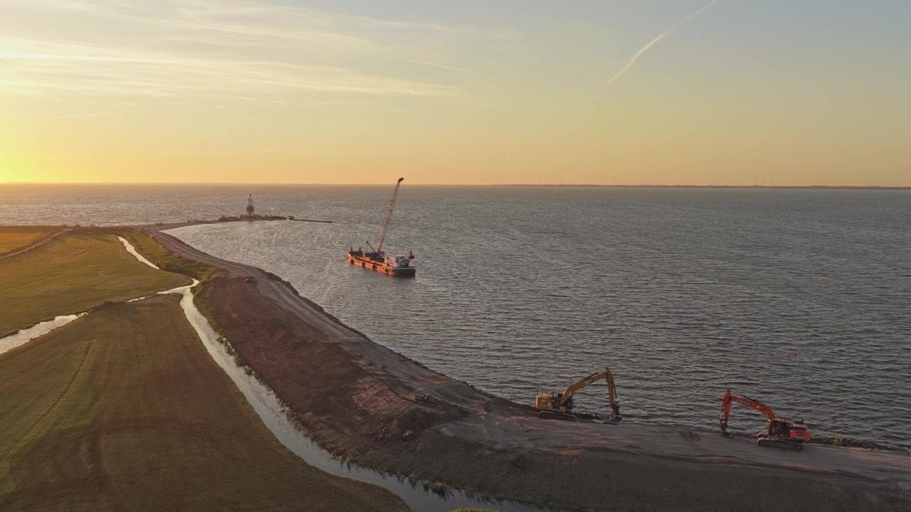 Vista aerea di costruzioni costiere e dragaggio al tramonto