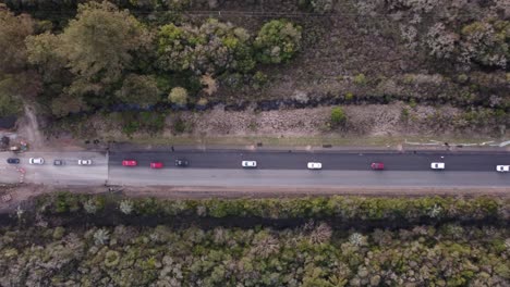 Vista-Aérea-De-Arriba-Hacia-Abajo-De-Un-Atasco-De-Tráfico-En-Una-Carretera-Forestal-Rural-En-El-Sur-De-Uruguay