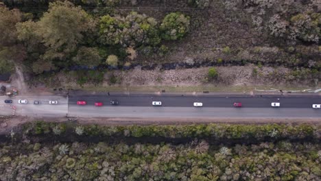 vista aérea de arriba hacia abajo de un atasco de tráfico en una carretera forestal rural en el sur de uruguay