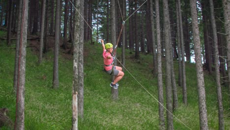 adventurous young female feeling accomplished and happy by swinging freely on a big hanging swing between trees