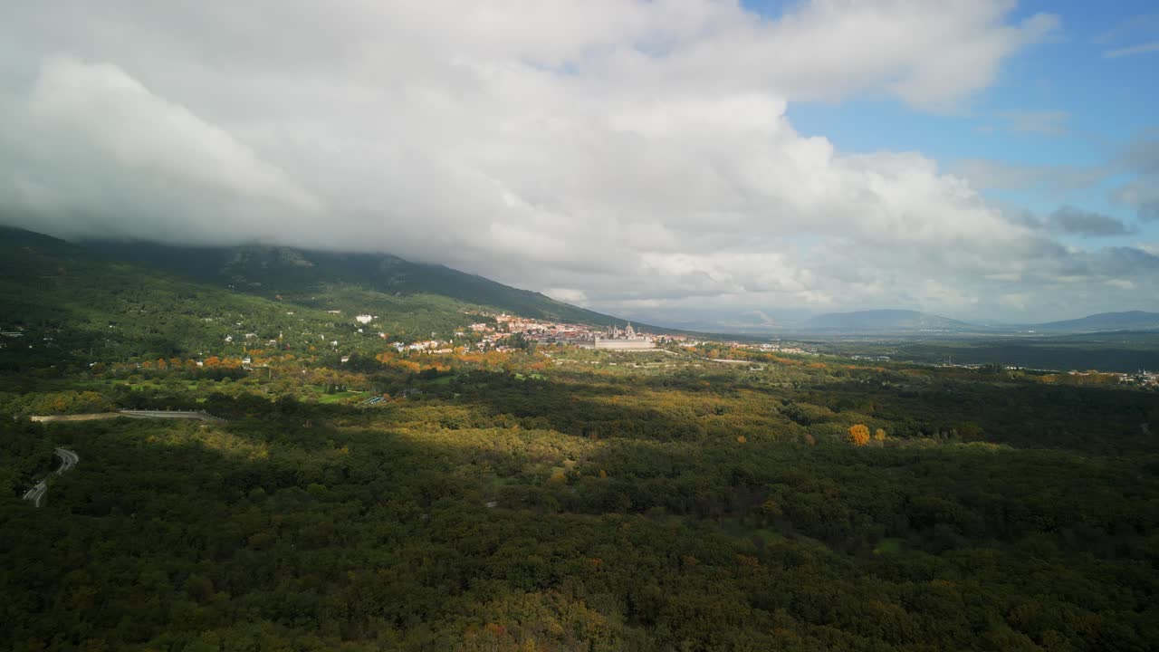 Vista aerea del Monastero e della città di El Escorial con nuvole in movimento su una foresta montana