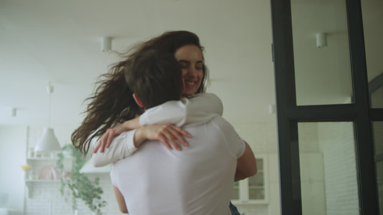 enamorados sonrientes abrazándose en la nueva casa. una pareja feliz dando vueltas en el nuevo hogar