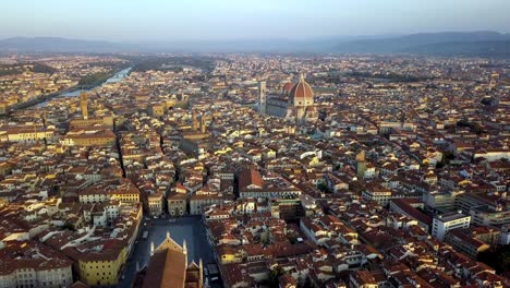 Basilica-of-Santa-Croce-front-and-Duomo-Fiore-cathedral-far-back-right,-Aerial-flyover-approach-shot