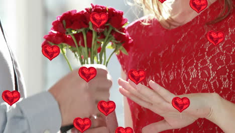 múltiples globos de corazón flotando contra el hombre poniendo un anillo en la mujer y besándola