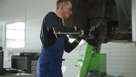 mechanic repairing car suspension