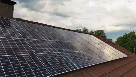 Solar panels installed on rooftop of house during sunny day, dolly shot rearward