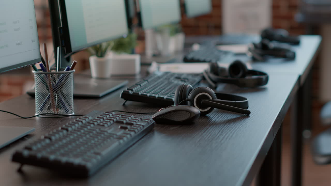 Empty desk with multiple monitors and modern gadgets