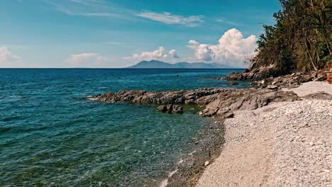 looc beach over a beach of shingles on a beautiful summer's day in the philippines with an aerial drone