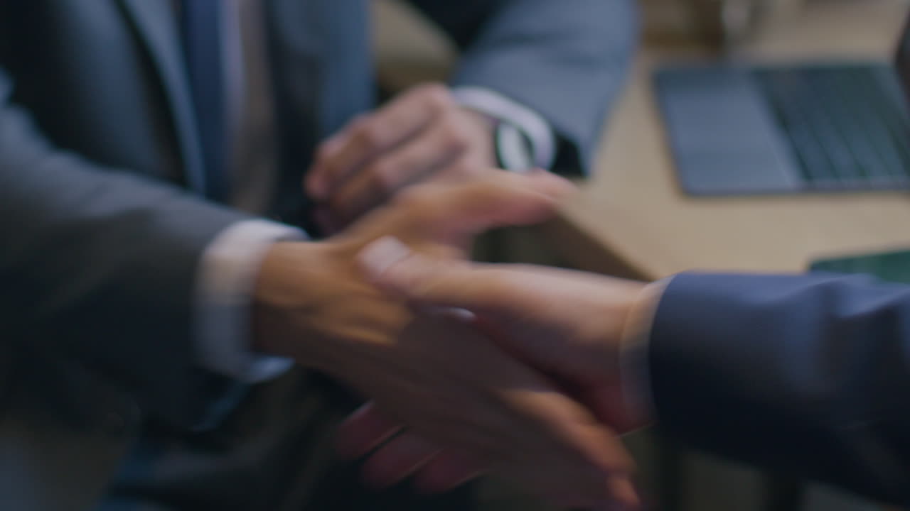 Close Up of Handshake between Colleagues after Business Meeting in Cafe