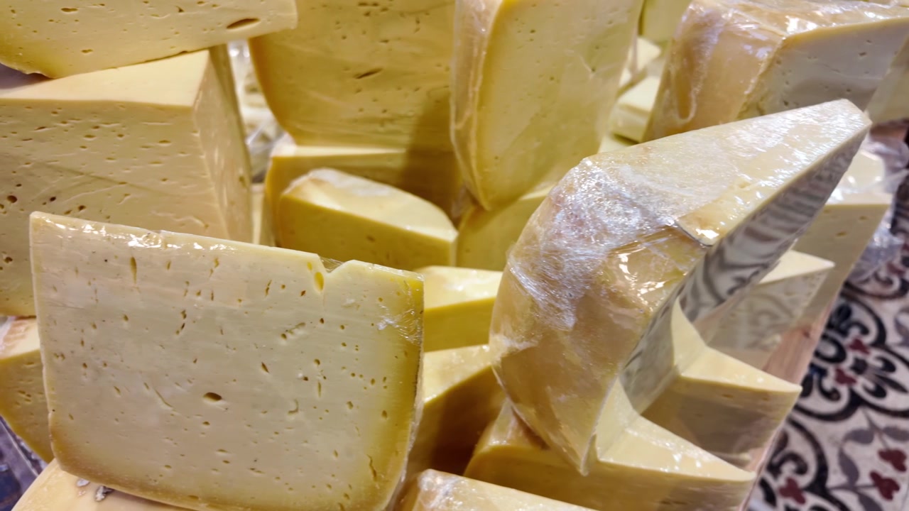 Assortimento di spicchi di formaggio fresco esposti in un mercato