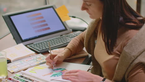 joven diseñador gráfico trabajando en una computadora de escritorio moderna mientras usa una tableta gráfica en el escritorio de la oficina.