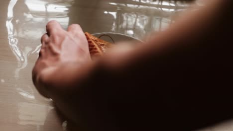close-up static shot of toasted wheat bread with peanut butter spread being placed on it for morning breakfast time