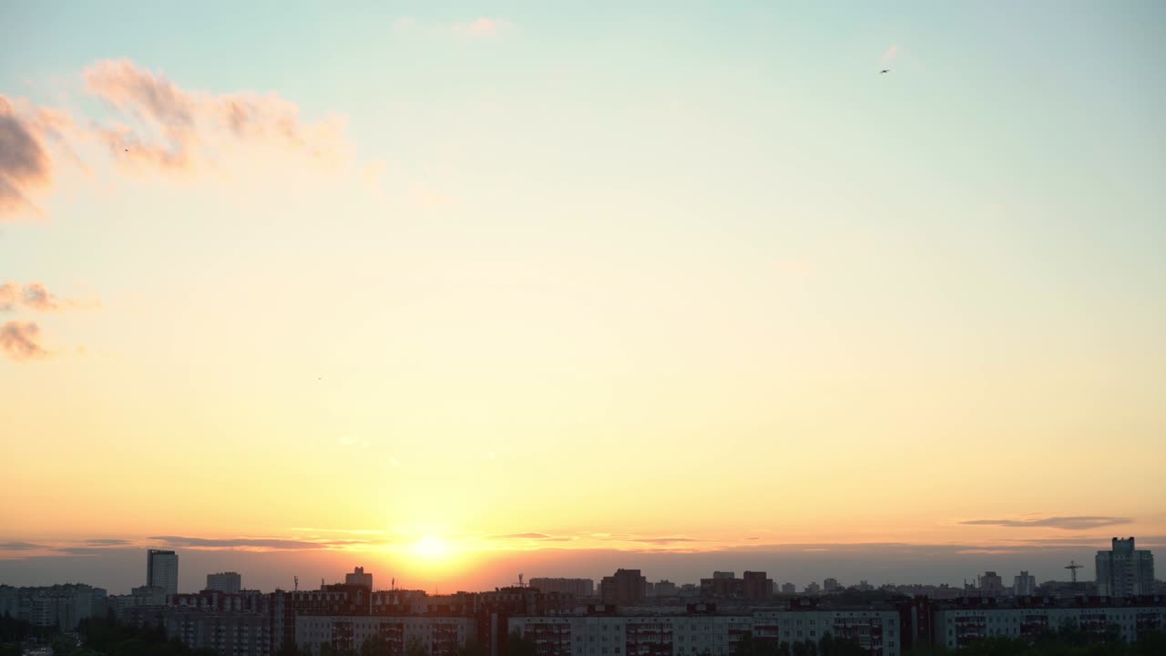 Sunset with sun bowl and clear sky with clouds flowing over residential district