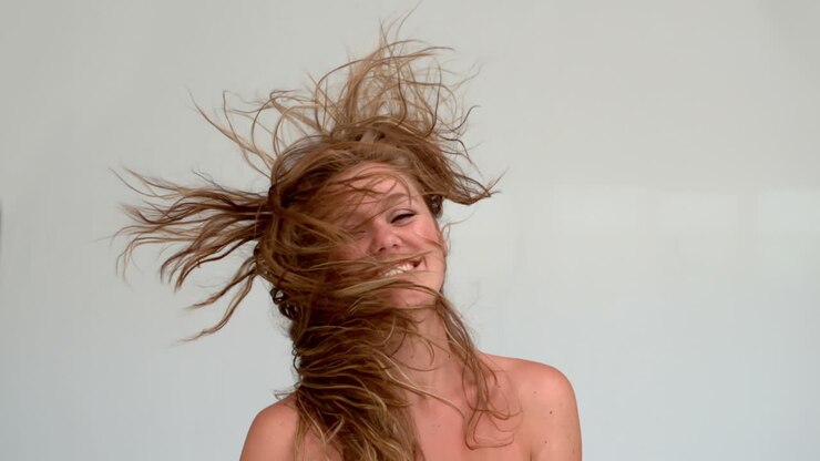 Vrouw schudt haar haar na het douchen