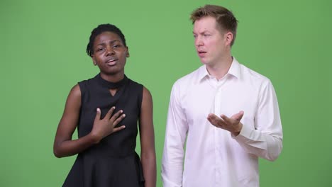 two young multi-ethnic business couple looking confused together
