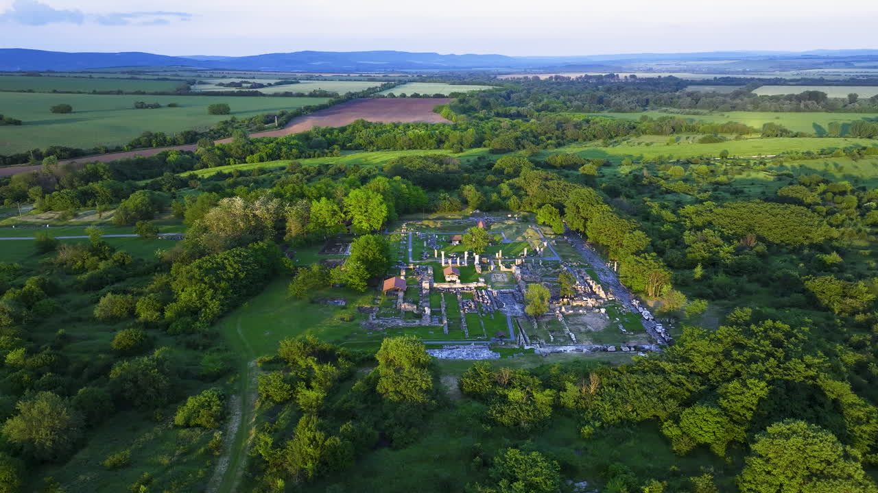 Orbiting drone view of Nicopolis ad Istrum at golden hour, with sunlight casting over ancient Roman