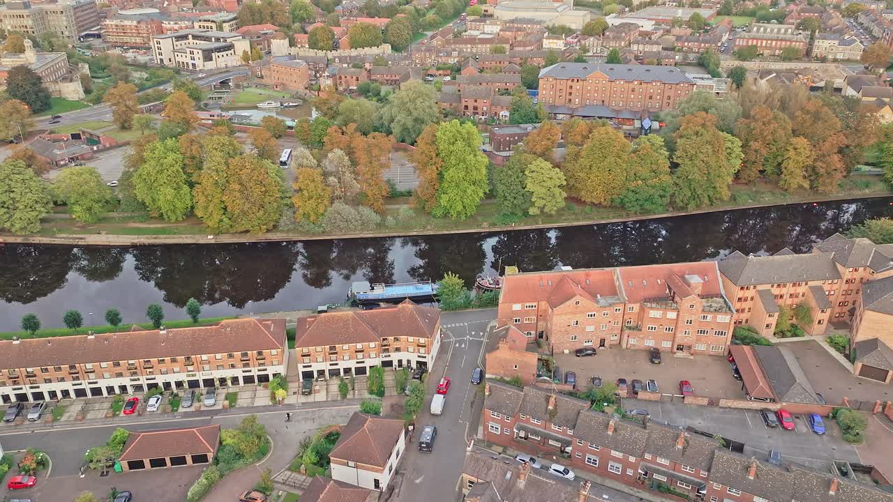 drone bajando disparó sobre un barrio en el centro de york con el reflejo de los árboles de colores de otoño en el río