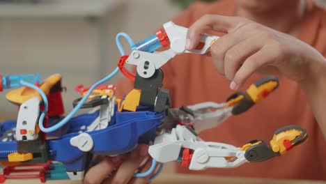 close up of asian boy's hand with a laptop assembling a cyborg hand at home