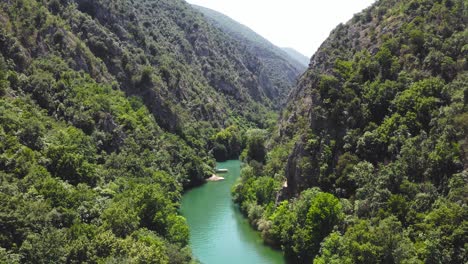 aerial dolly in through matka gorge and forest with a river flowing through it at sunlight