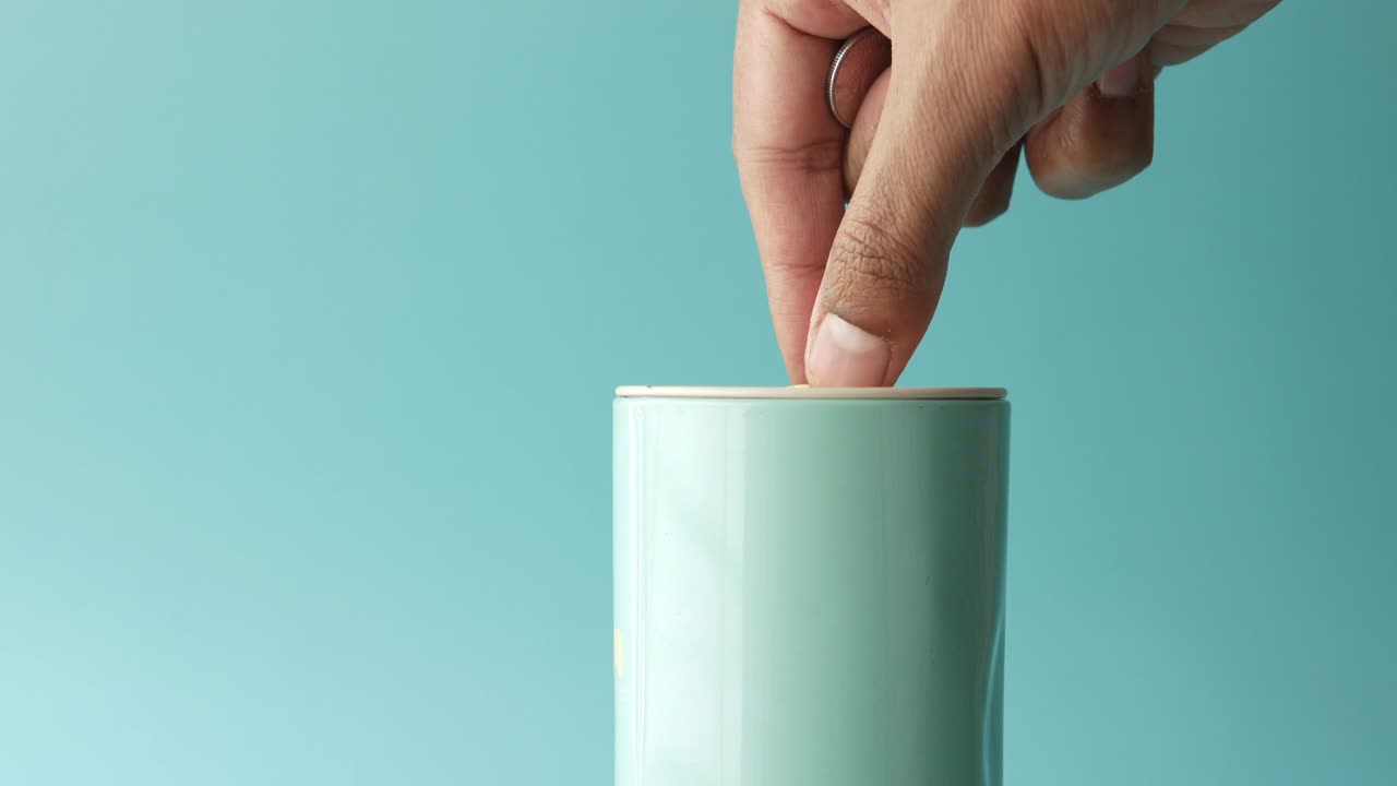 젊은이 가 복사 공간 을 가진 항아리 에 동전 을 저장 하고 있다