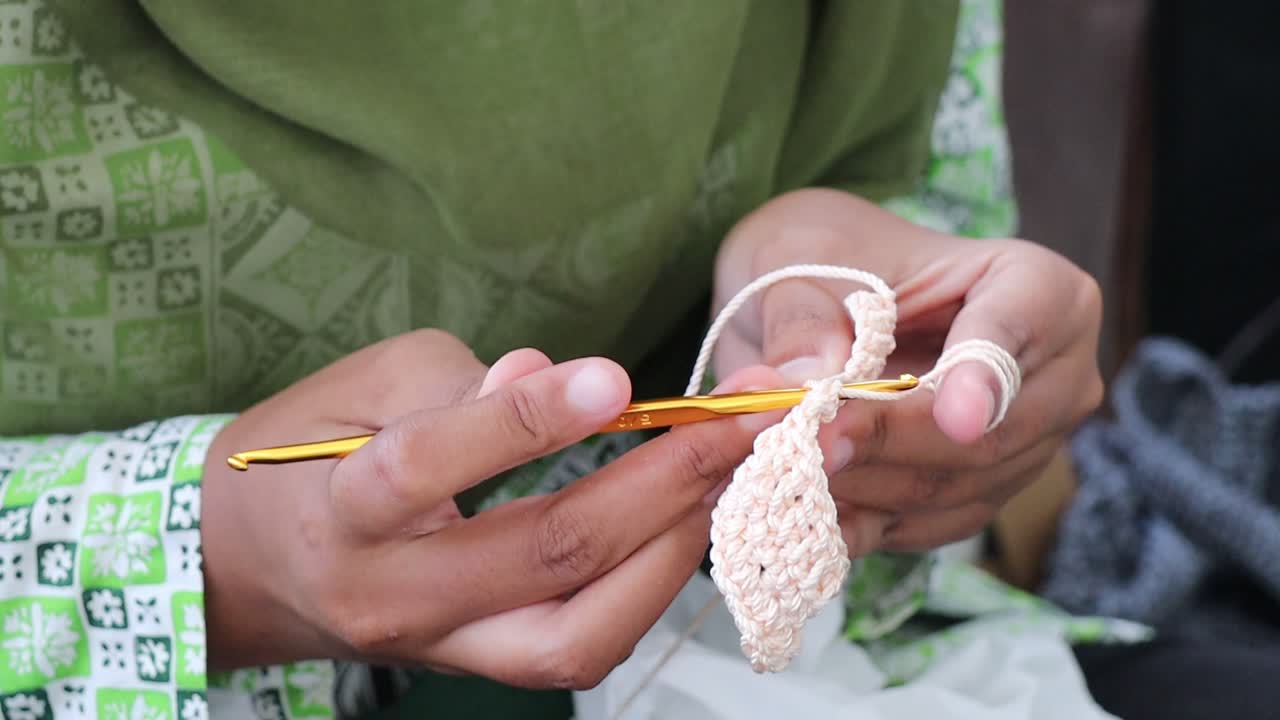 Close up shot of a woman knits wool with her hands and sewing needles on a studio set, traditional manual needles knitting craft.
