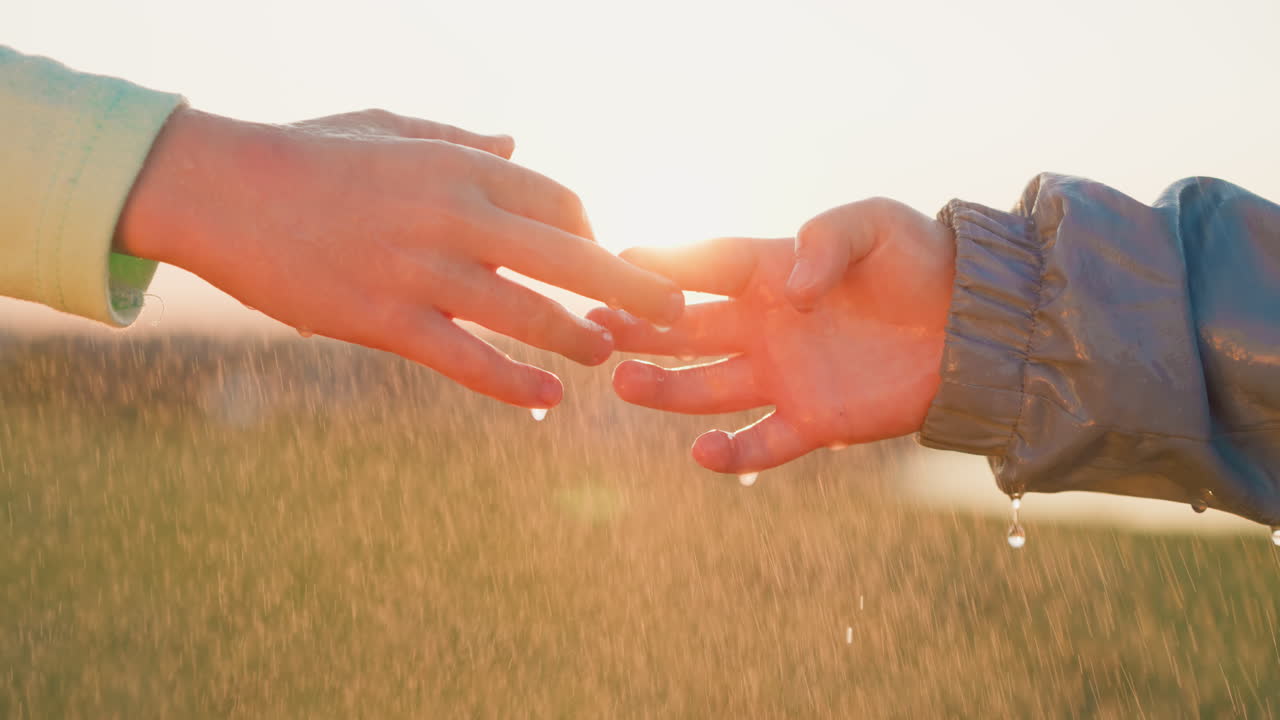 소녀는 비가 내리는 동안 소년의 손가락을 만지며 가까이에서 아이들은 평생 지속되는 소중한 기억을 만니다.