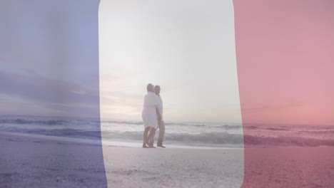 animación de la bandera de francia sobre una pareja biracial mayor caminando por la playa.