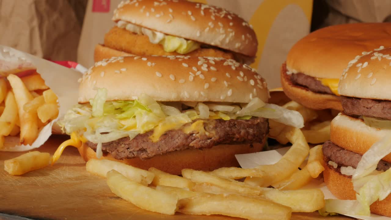 porción de comida no saludable, comida rápida, pila de hamburguesas, patatas fritas girando, girando